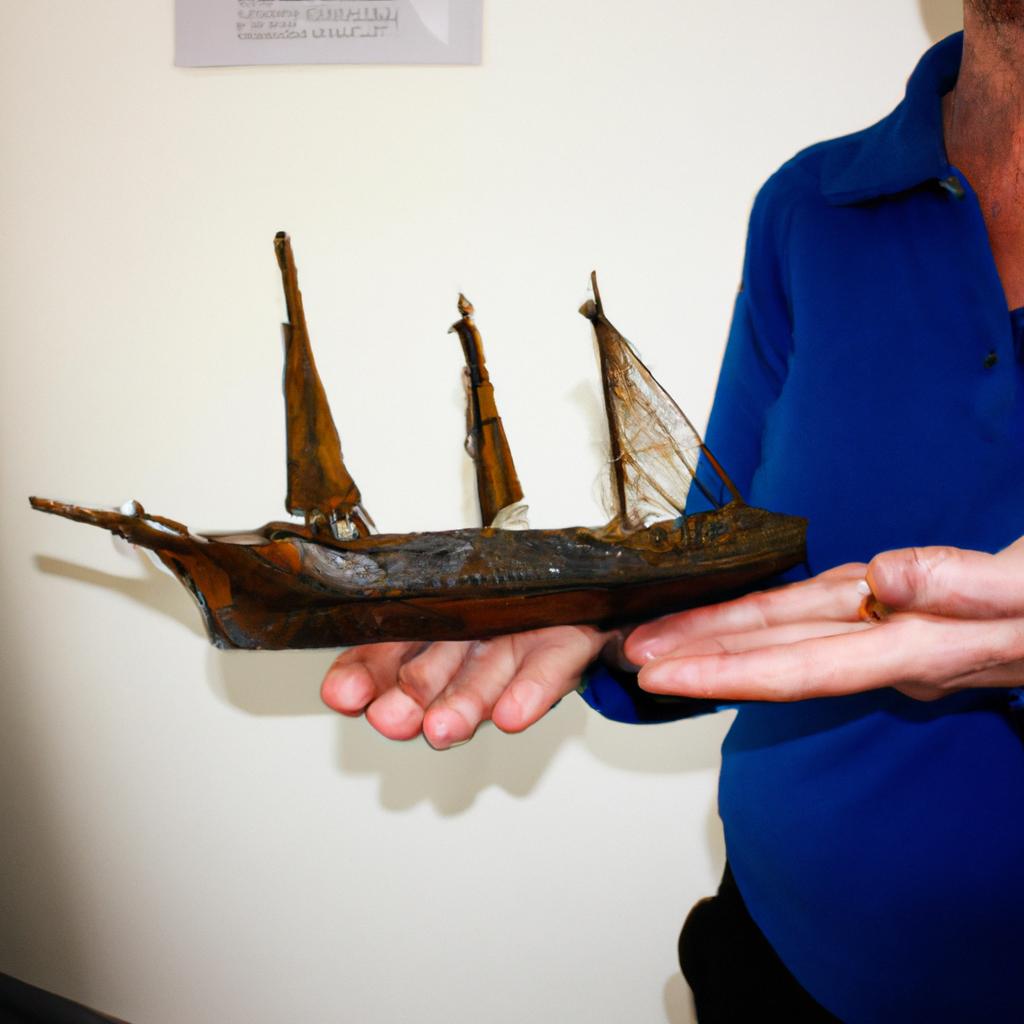 Person holding museum ship artifacts